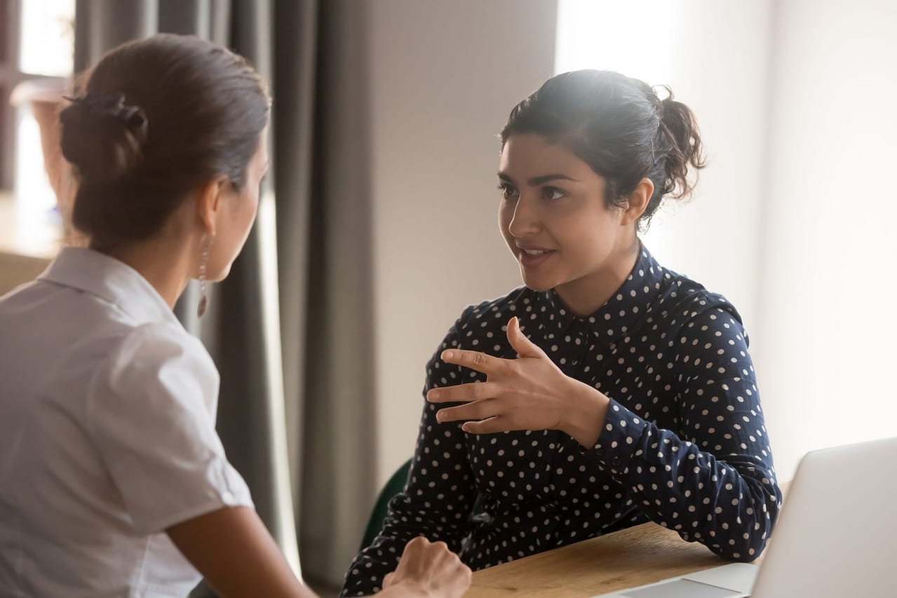 serious indian mentor worker talk to female colleague teach intern