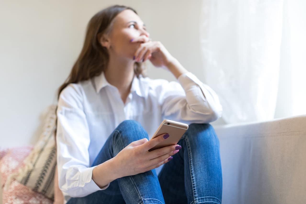 portrait of blurred thoughtful depressed woman sitting on sofa