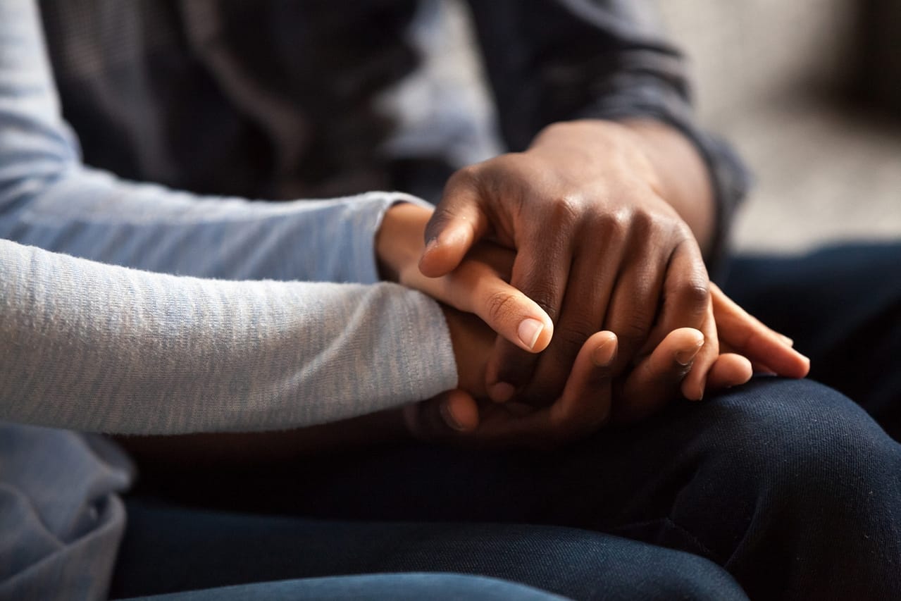 close up black male and female holds hands
