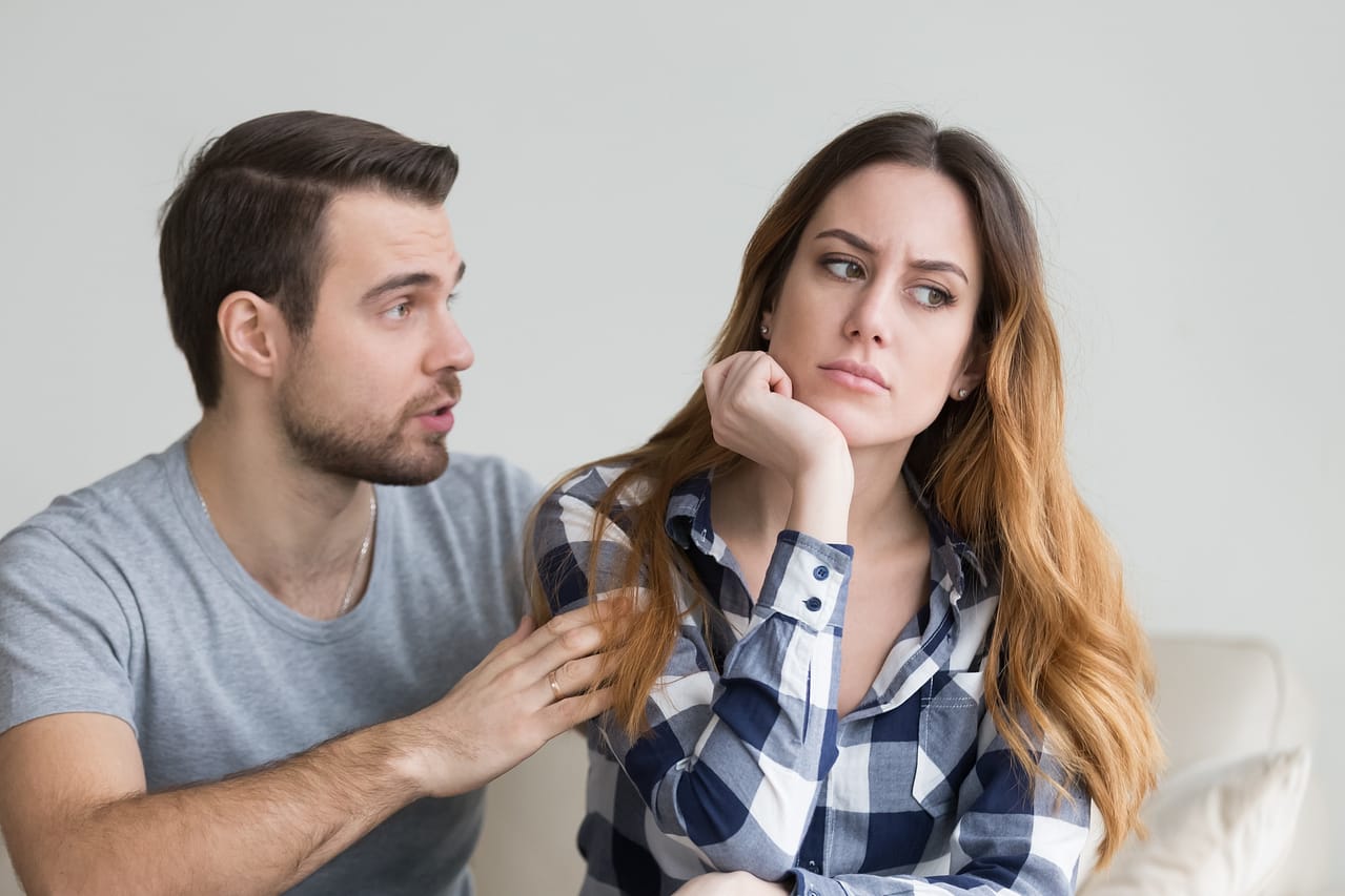 Ablehnung vom Partner in der Beziehung: So kannst du damit umgehen! 2 Junges Paar streitet sich im Wohnzimmer.
