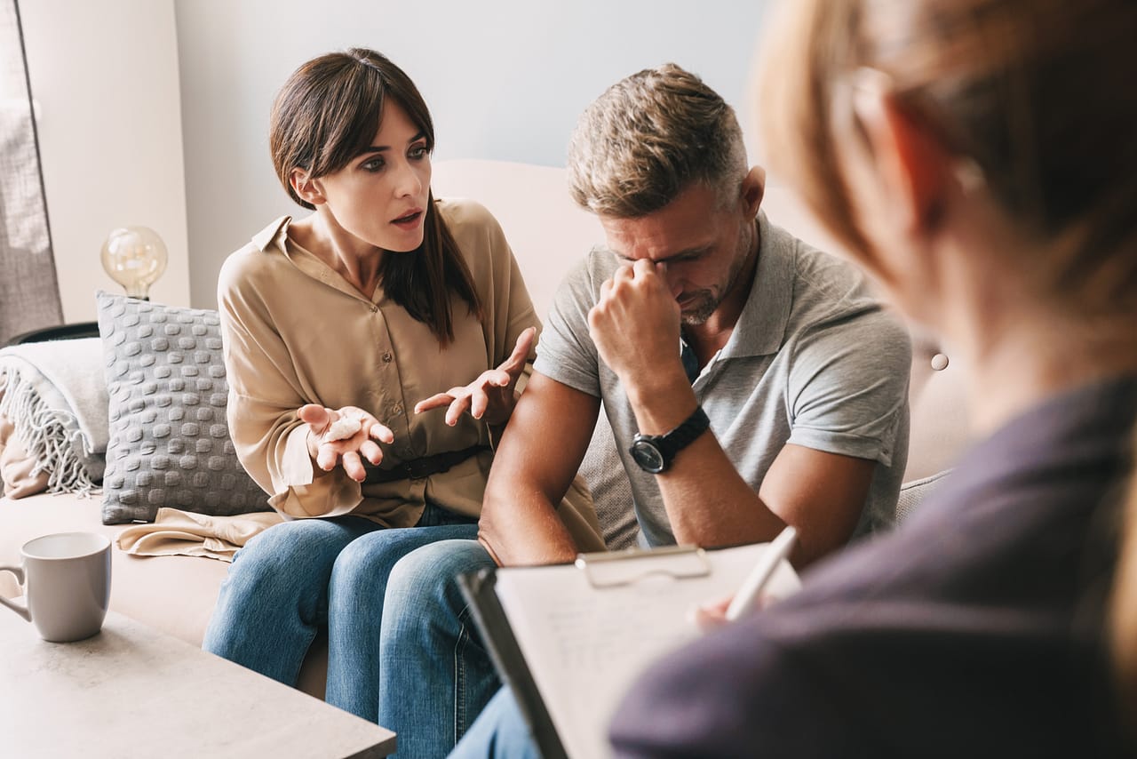 Frau wirft ihrem Mann im Coaching verschiedene Dinge vor.