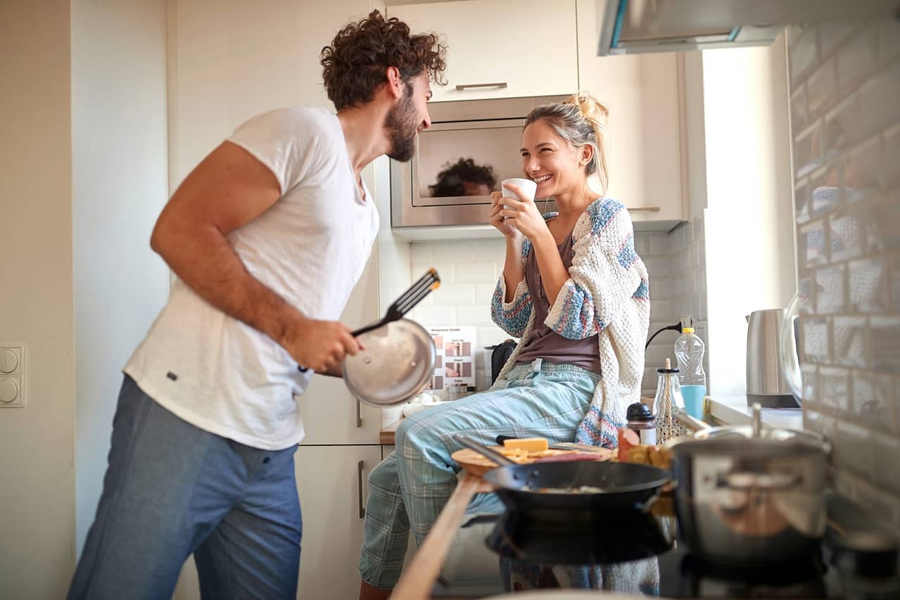 a young couple in love having good time while preparing a breakf